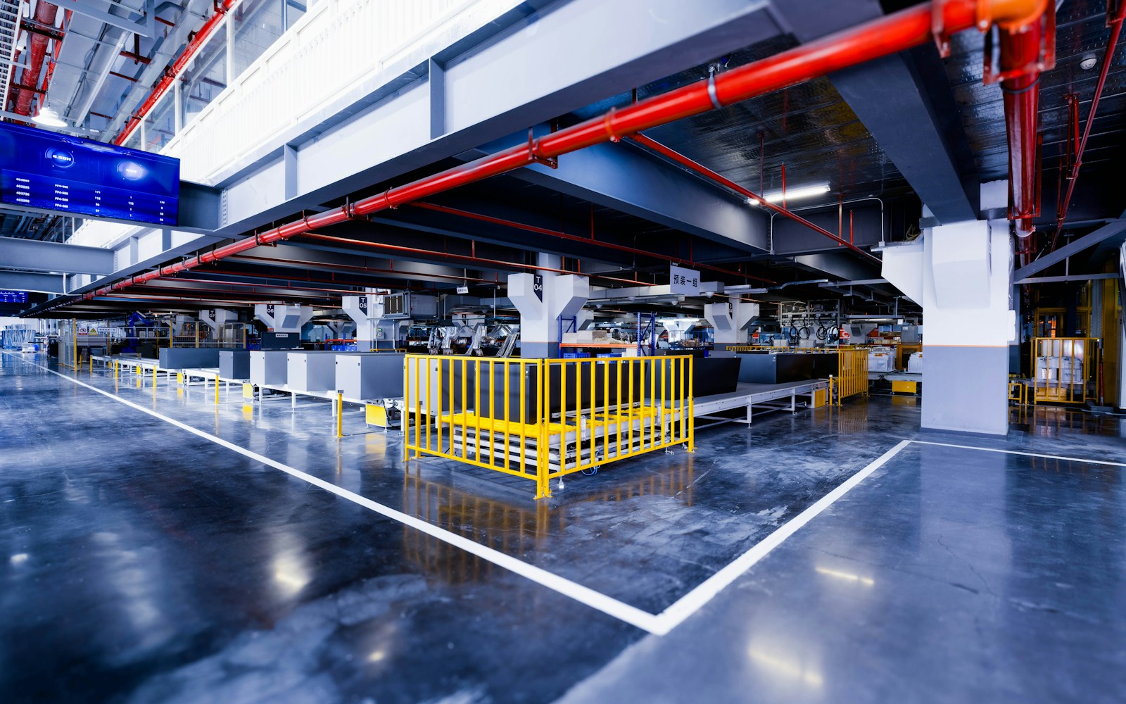 Orderly industrial production floor with marked work zones and installed equipment.